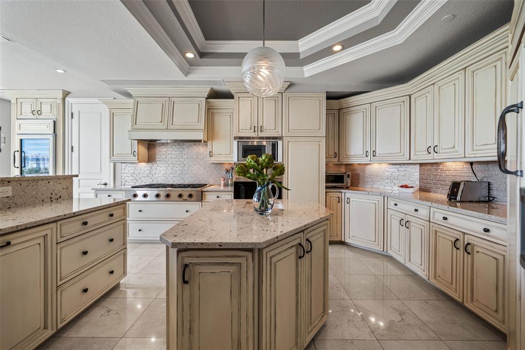 464 Golden Gate Point, Unit 703 Sarasota, FL 34236 - Photo 28 of 88 a kitchen with kitchen island granite countertop a sink window and cabinets