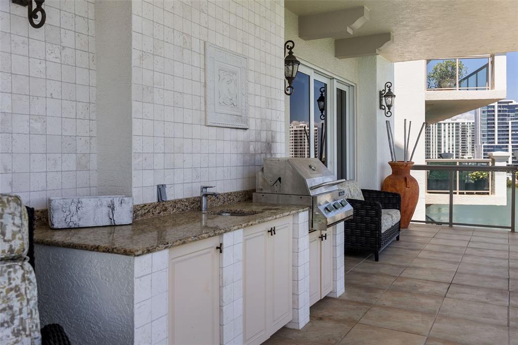 464 Golden Gate Point, Unit 703 Sarasota, FL 34236 - Photo 38 of 88 a kitchen with granite countertop a sink and a stove
