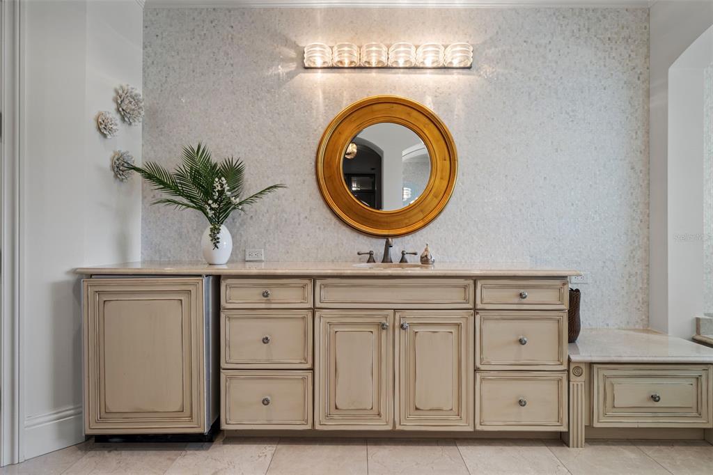 464 Golden Gate Point, Unit 703 Sarasota, FL 34236 - Photo 47 of 88 a bathroom with a sink a mirror and a potted plant