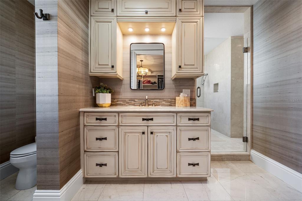 464 Golden Gate Point, Unit 703 Sarasota, FL 34236 - Photo 57 of 88 a bathroom with a sink a toilet and a mirror