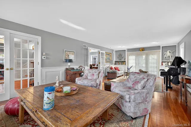 a living room with furniture a wooden floor and a large window