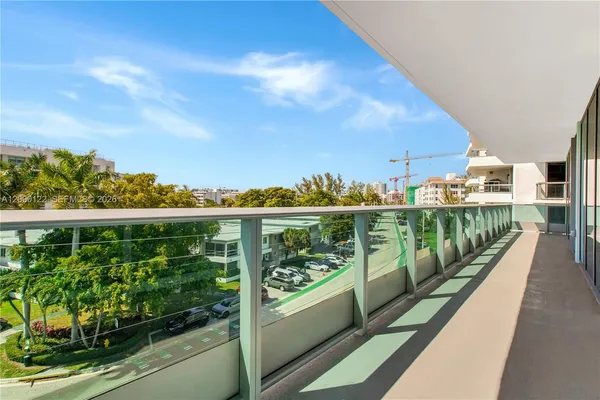 a dining hall with stainless steel appliances a dining table and chairs with kitchen view