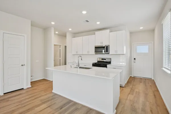 a kitchen with white cabinets and stainless steel appliances
