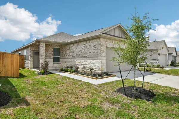a front view of a house with garden and plants