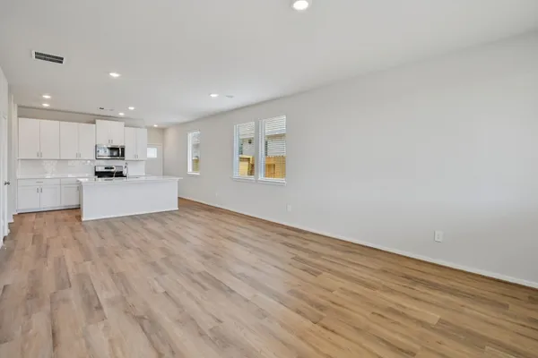 a view of a kitchen with wooden floor and electronic appliances