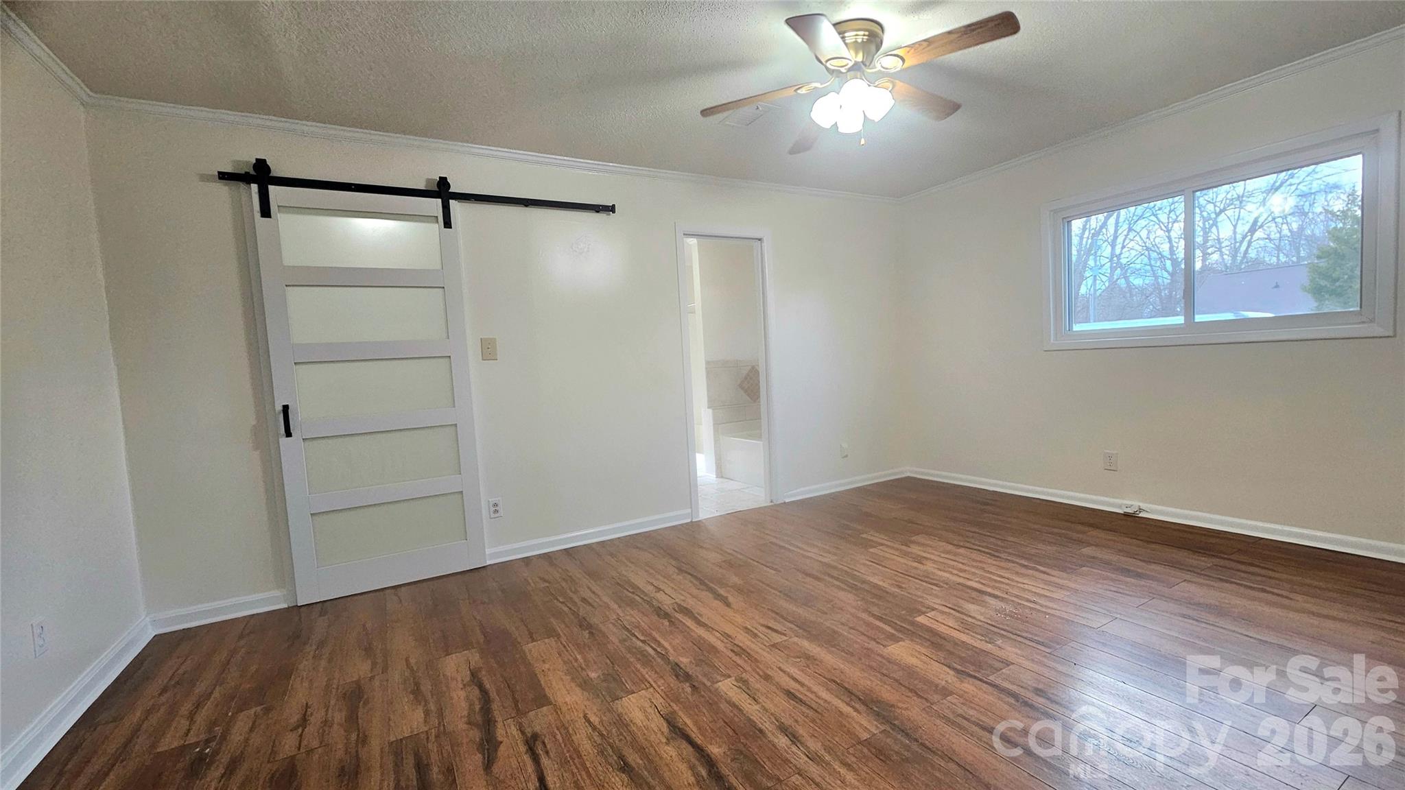 107 Oakgrove Street Locust, NC 28097 - Photo 16 of 32 a view of empty room with wooden floor and fan