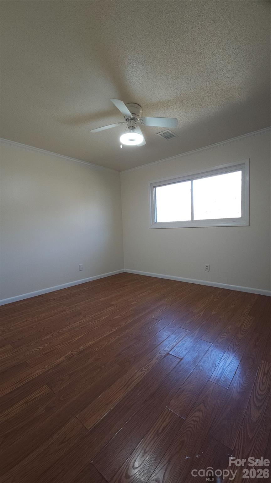 107 Oakgrove Street Locust, NC 28097 - Photo 21 of 32 an empty room with wooden floor and windows in it
