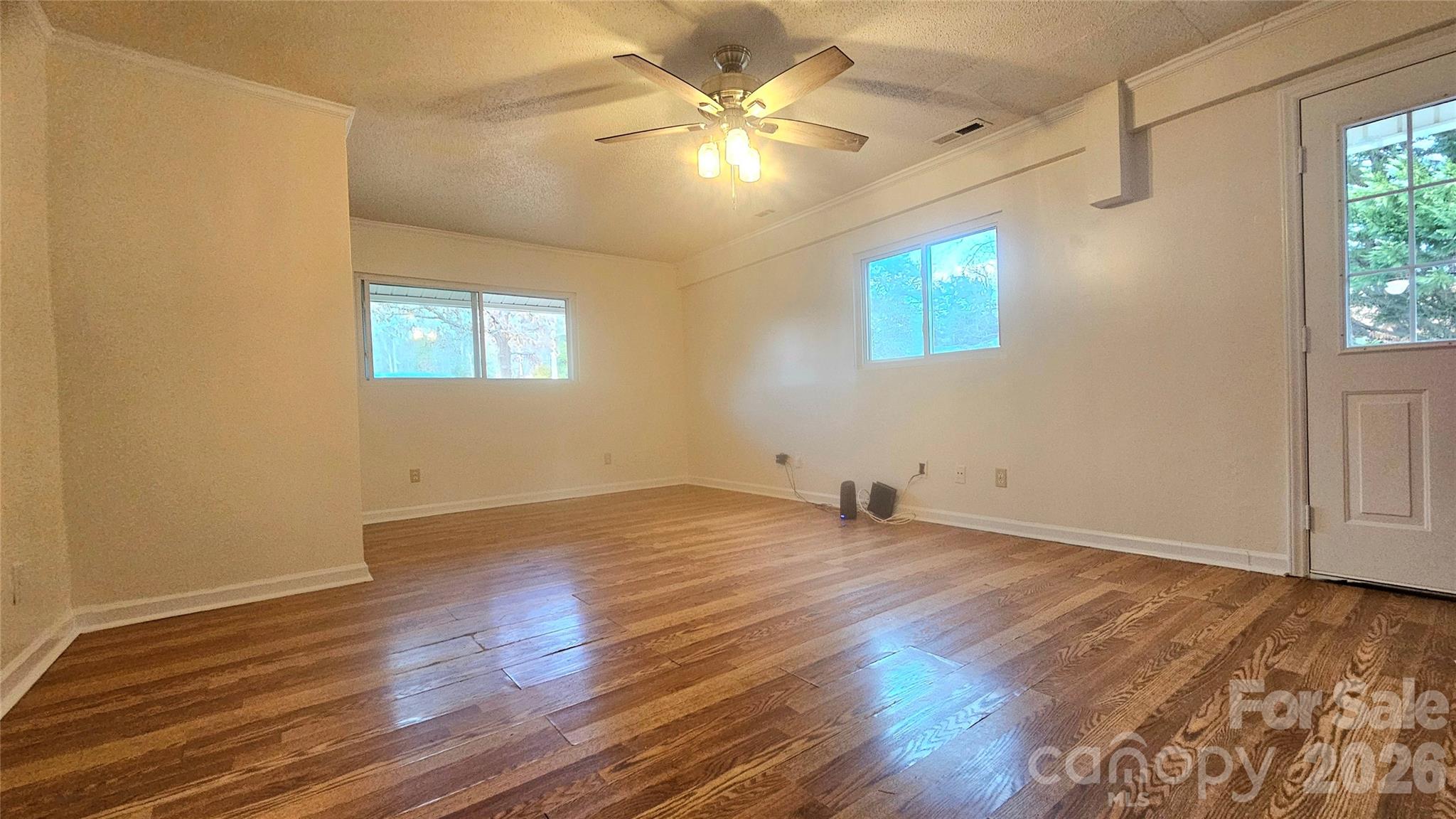 107 Oakgrove Street Locust, NC 28097 - Photo 25 of 32 an empty room with wooden floor and windows