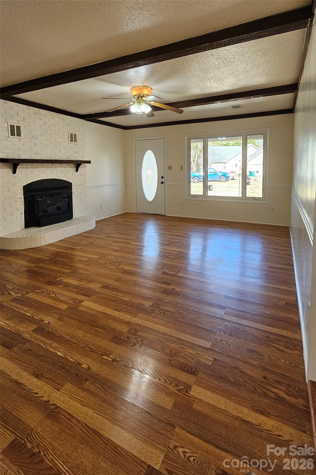 107 Oakgrove Street Locust, NC 28097 - Photo 5 of 32 a view of a livingroom with wooden floor and a fireplace