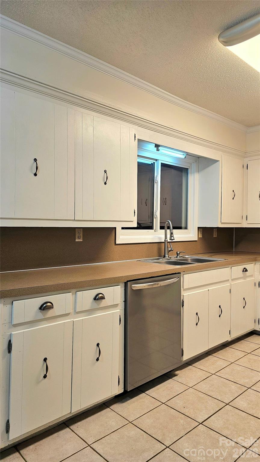 107 Oakgrove Street Locust, NC 28097 - Photo 9 of 32 a kitchen with granite countertop white cabinets white appliances with a sink and dishwasher