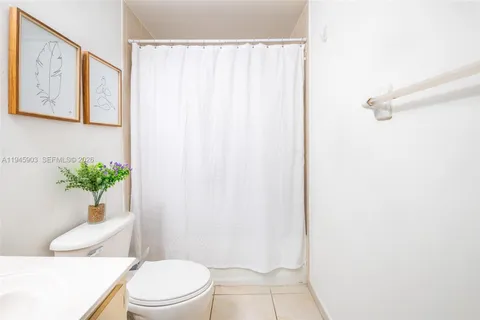 a bathroom with a sink a toilet and shower curtain
