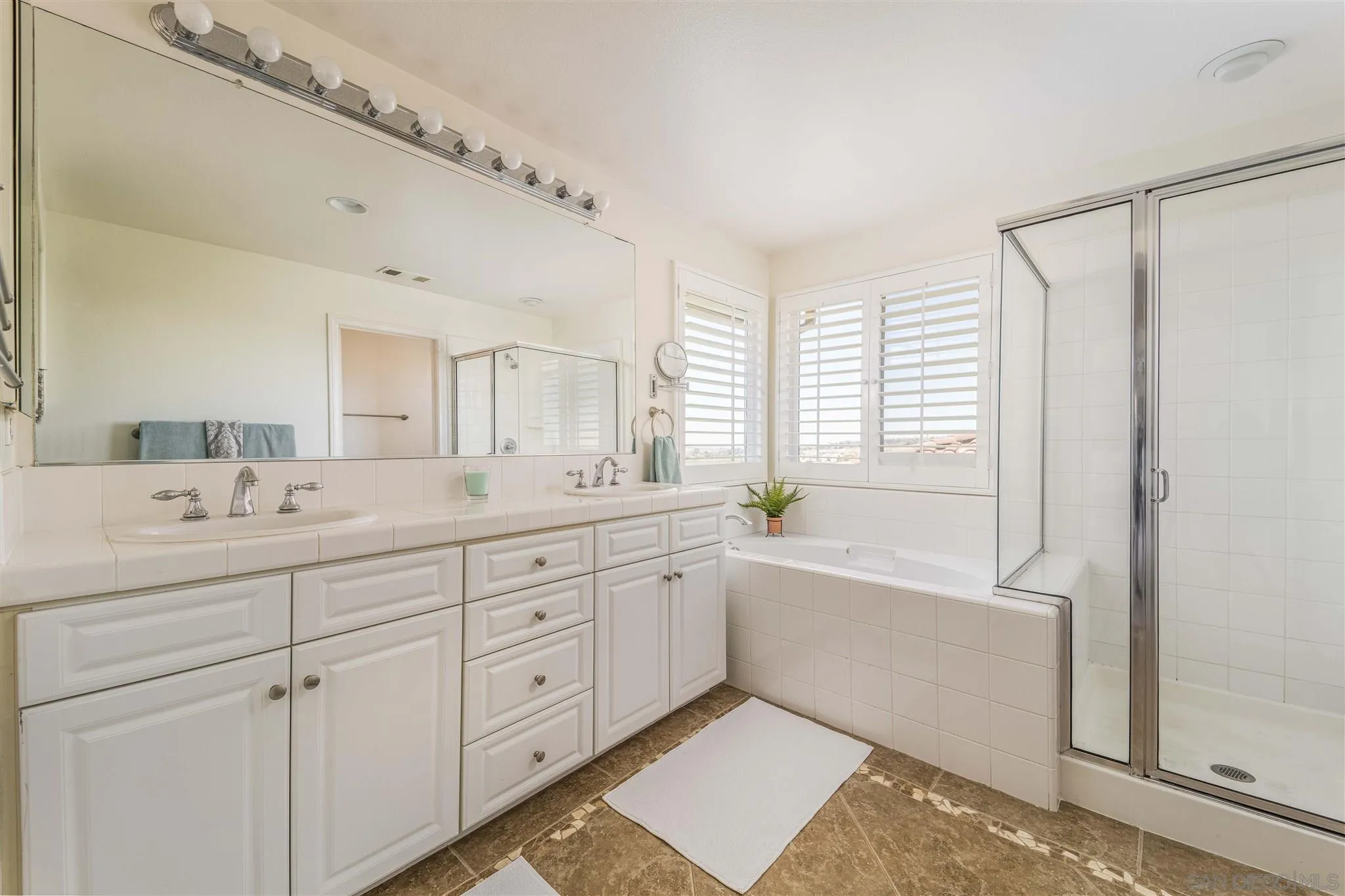 4757 Crater Rim Road Carlsbad, CA 92010 - Photo 19 of 26 a spacious bathroom with a double vanity sink a mirror and a bathtub