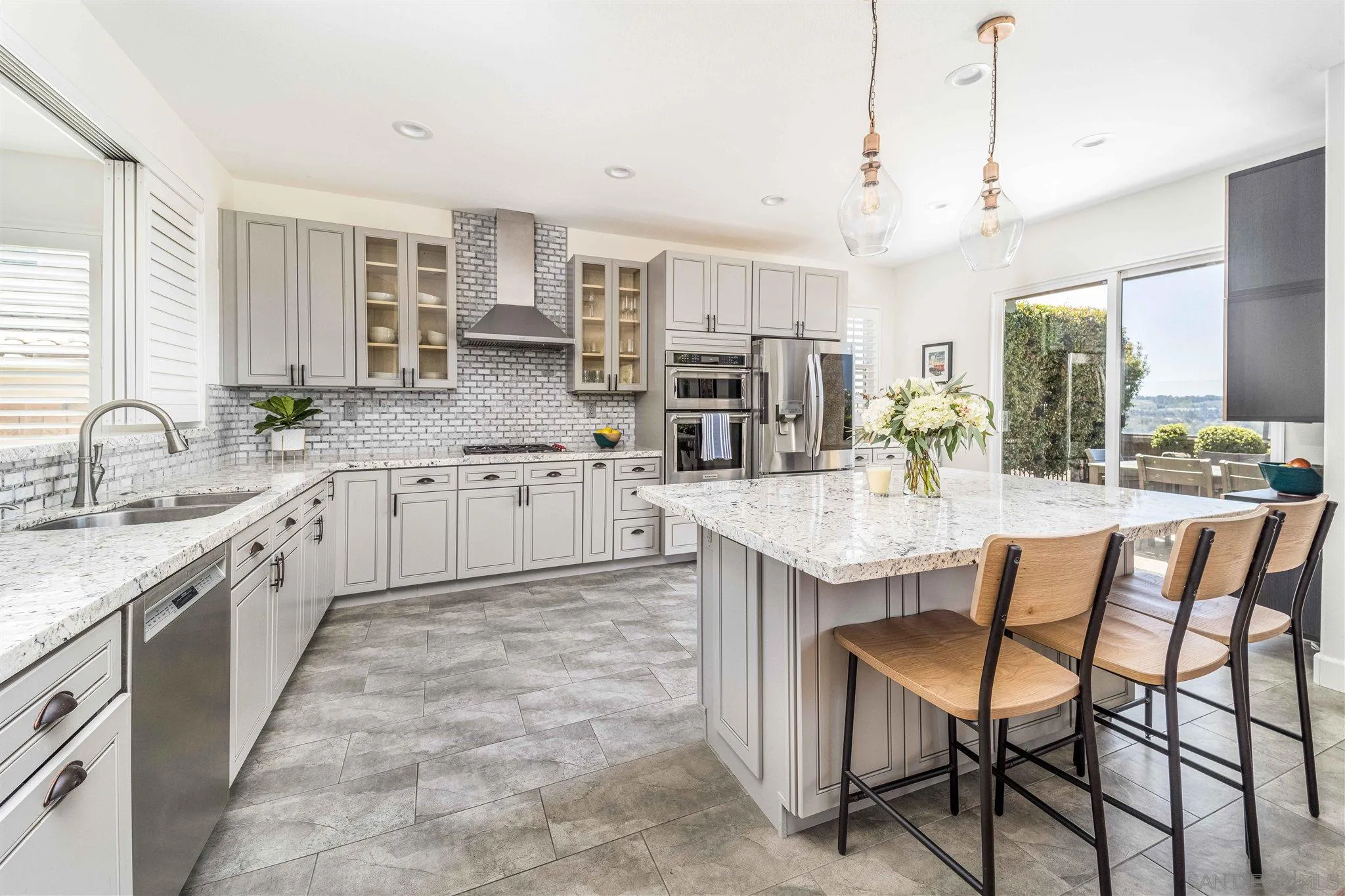 4757 Crater Rim Road Carlsbad, CA 92010 - Photo 5 of 26 a large kitchen with kitchen island granite countertop a sink and cabinets