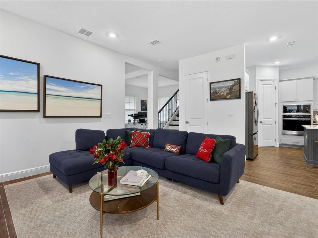 9952 Rodbell Street Orlando, FL 32827 - Photo 5 of 44 a living room with furniture and a wooden floor