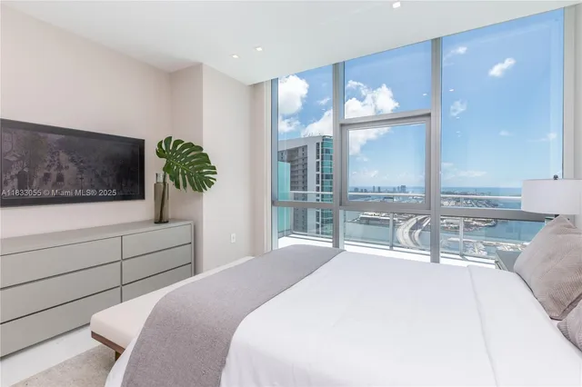 a bedroom with a large bed and a large window