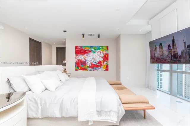 a bedroom with a bed and a painting on the wall