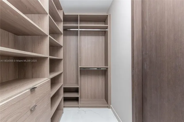 a view of walk in closet with empty racks