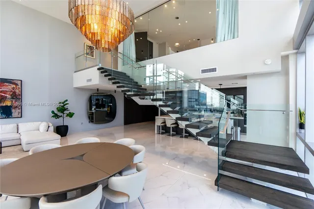 a living room with furniture a chandelier and a dining table
