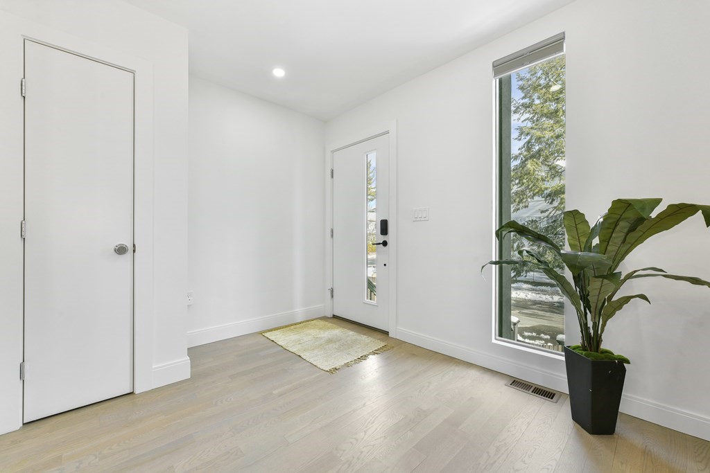 63 Alpine Street, Unit 1 Cambridge, MA 02138 - Photo 2 of 27 an empty room with windows and flower pot
