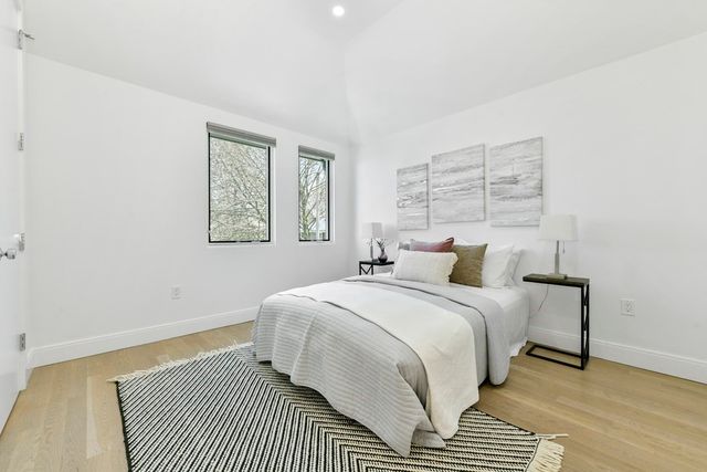 a bedroom with a bed lamp and a window