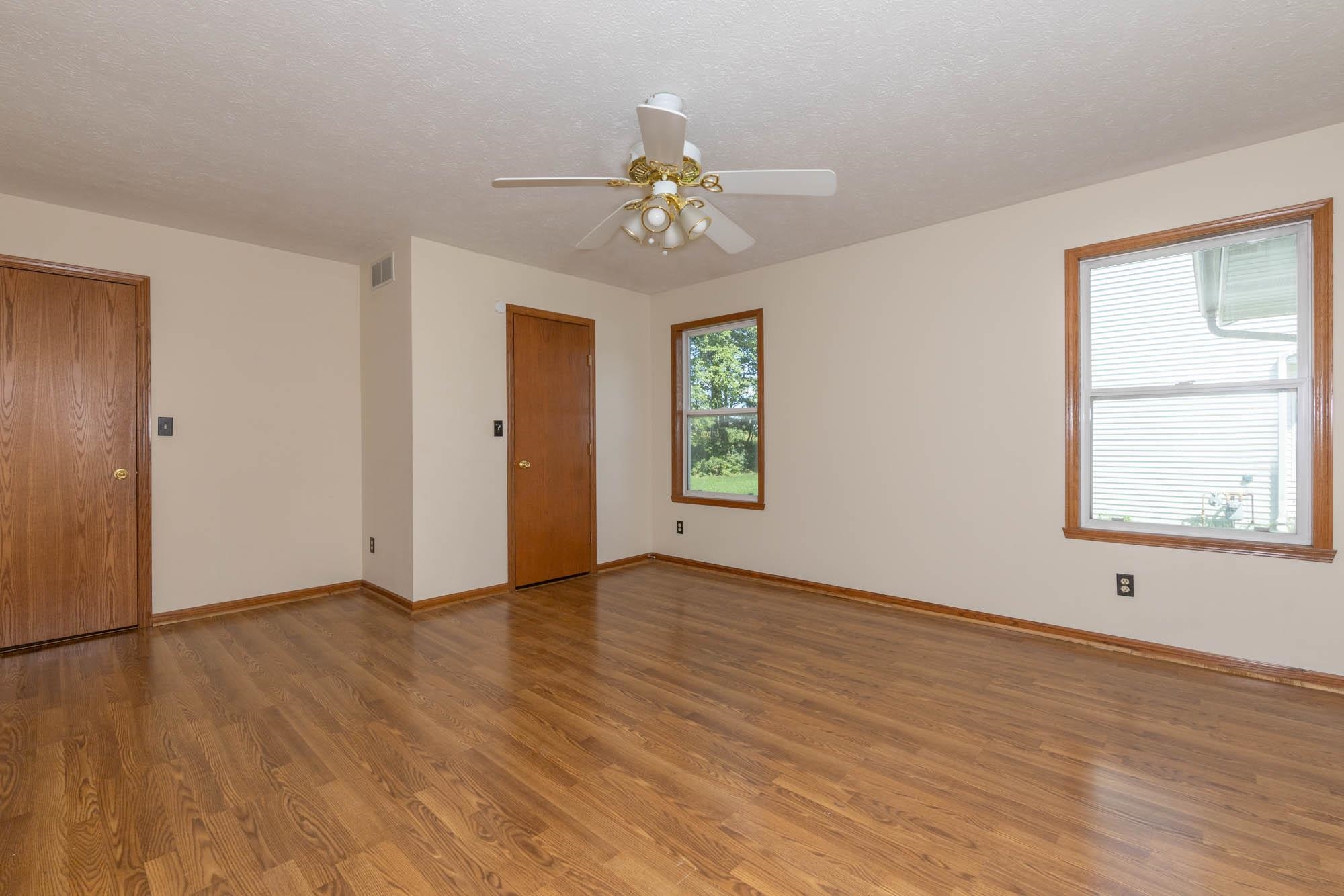 10686 Meadowsweet Lane Roscoe, IL 61073 - Photo 15 of 33 an empty room with wooden floor chandelier and windows