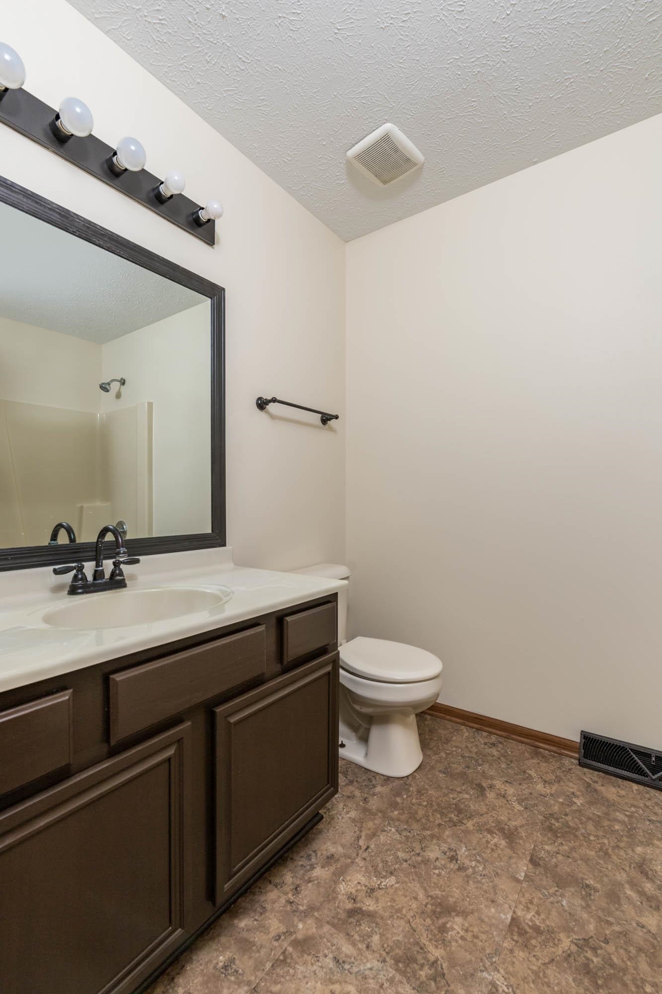 10686 Meadowsweet Lane Roscoe, IL 61073 - Photo 21 of 33 a bathroom with a granite countertop sink a toilet and a mirror
