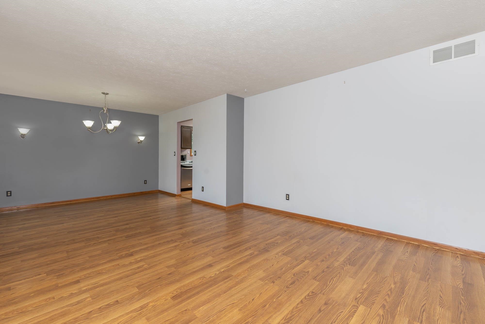 10686 Meadowsweet Lane Roscoe, IL 61073 - Photo 6 of 33 a view of an empty room with wooden floor and a window