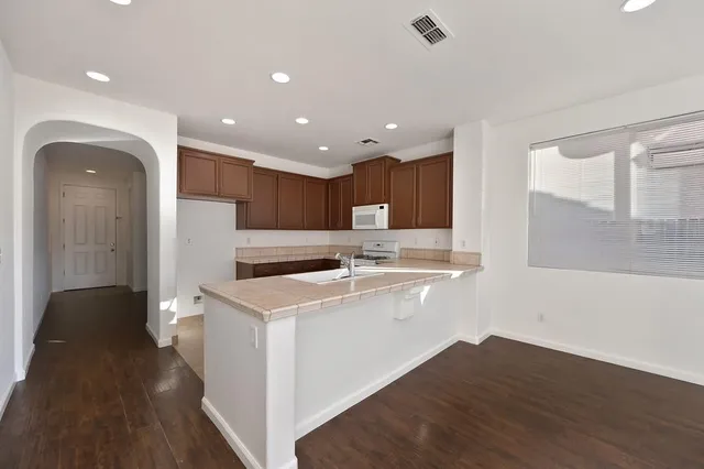 a kitchen with a refrigerator a sink and wooden floor