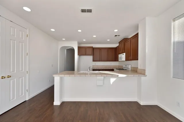 a large white kitchen with wooden floors and a fireplace