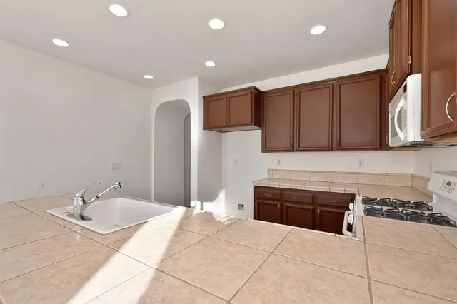 a kitchen with stainless steel appliances granite countertop a sink a stove and a refrigerator