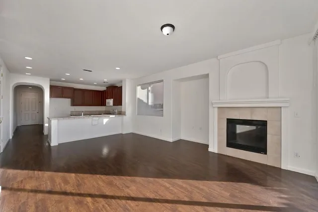 a view of a living room kitchen with a fireplace and wooden floor