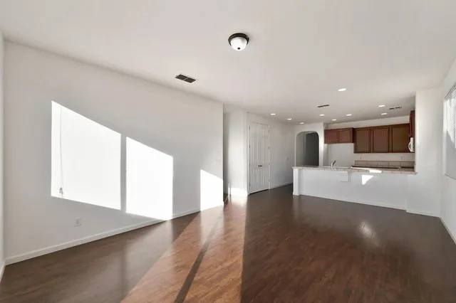 a view of a big room with wooden floor and windows