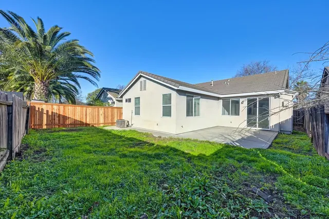 a view of a house with a yard and potted plants