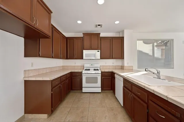 a kitchen with a sink stove top oven and cabinets
