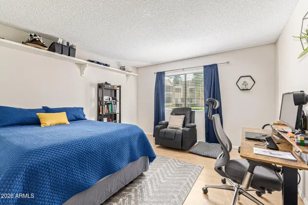 a bedroom with a bed and wooden floor