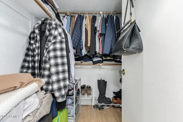 a view of walk in closet with clothes and shoes