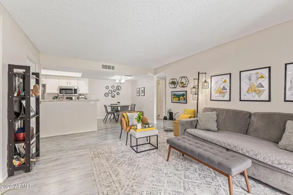 a living room with furniture and a dining table with wooden floor