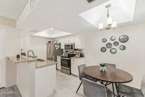 a kitchen with stainless steel appliances granite countertop a sink and a refrigerator