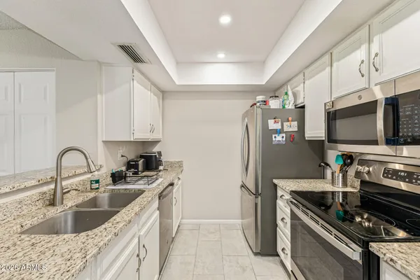 a kitchen with stainless steel appliances kitchen island granite countertop a sink and a stove
