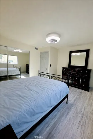 a spacious bedroom with a bed and a dresser