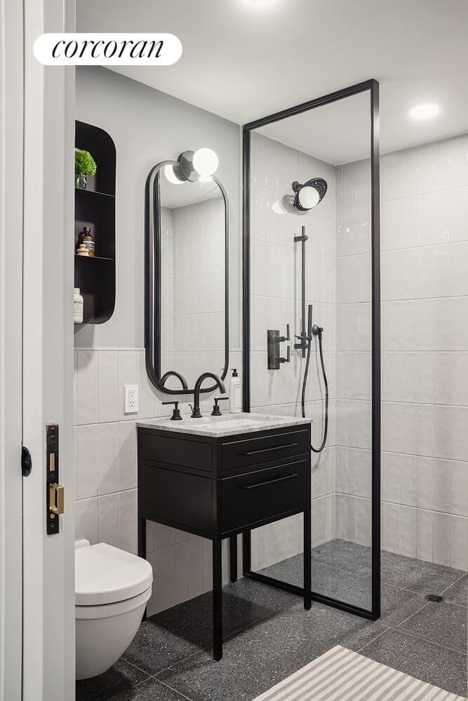 547 West 47th Street, Unit 313 Manhattan, NY 10036 - Photo 8 of 30 a bathroom with a toilet a sink and mirror