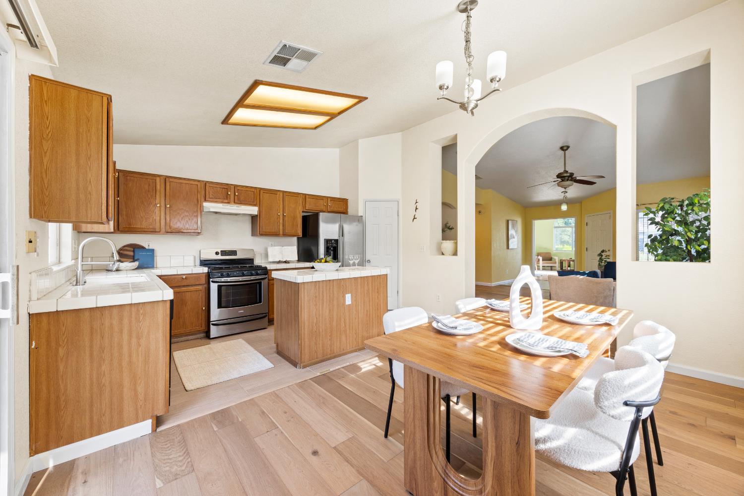 8926 Generations Court Elk Grove, CA 95758 - Photo 11 of 23 a view of a dining room with furniture a chandelier and wooden floor