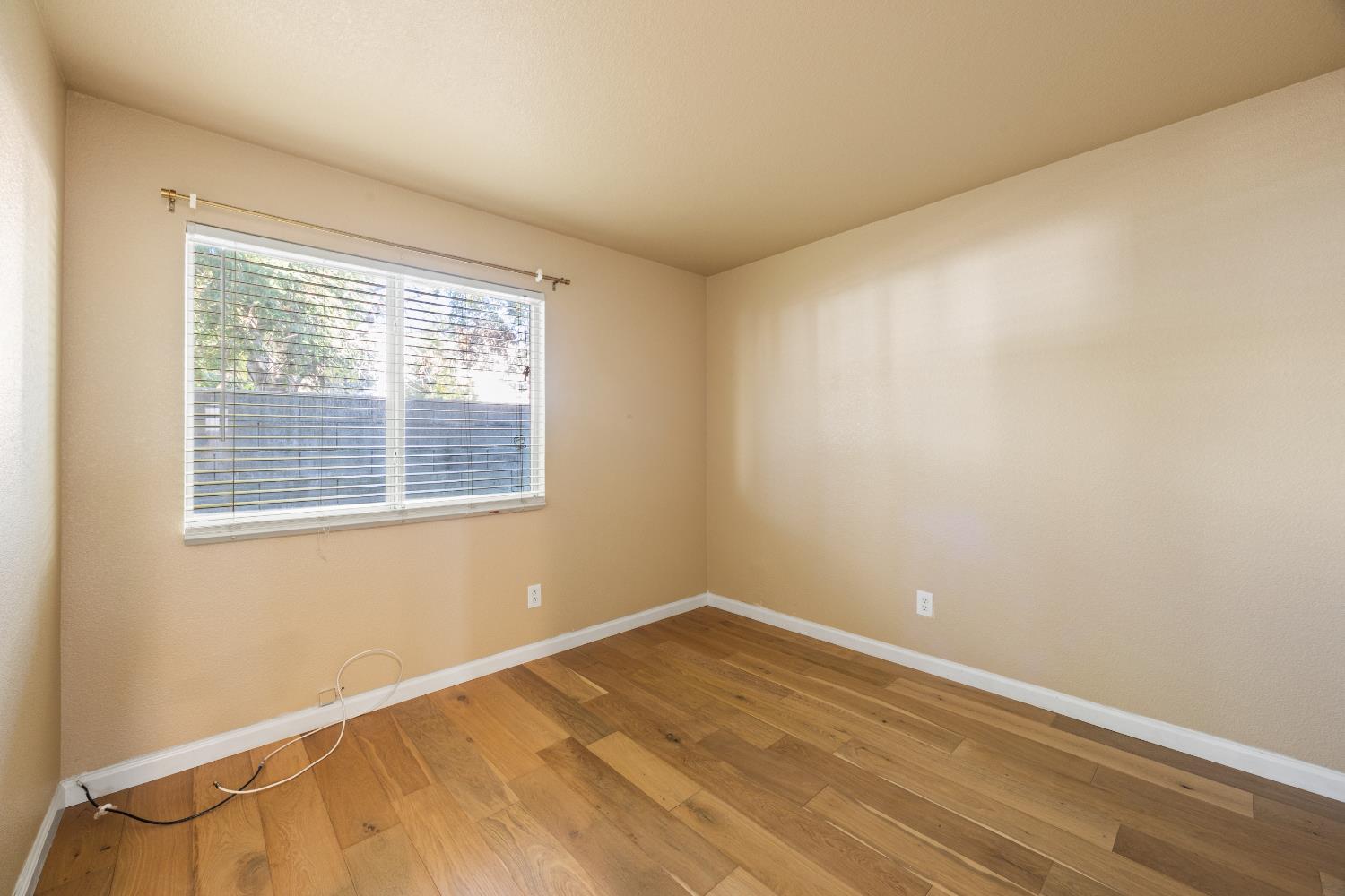 8926 Generations Court Elk Grove, CA 95758 - Photo 15 of 23 a view of an empty room with wooden floor and a window