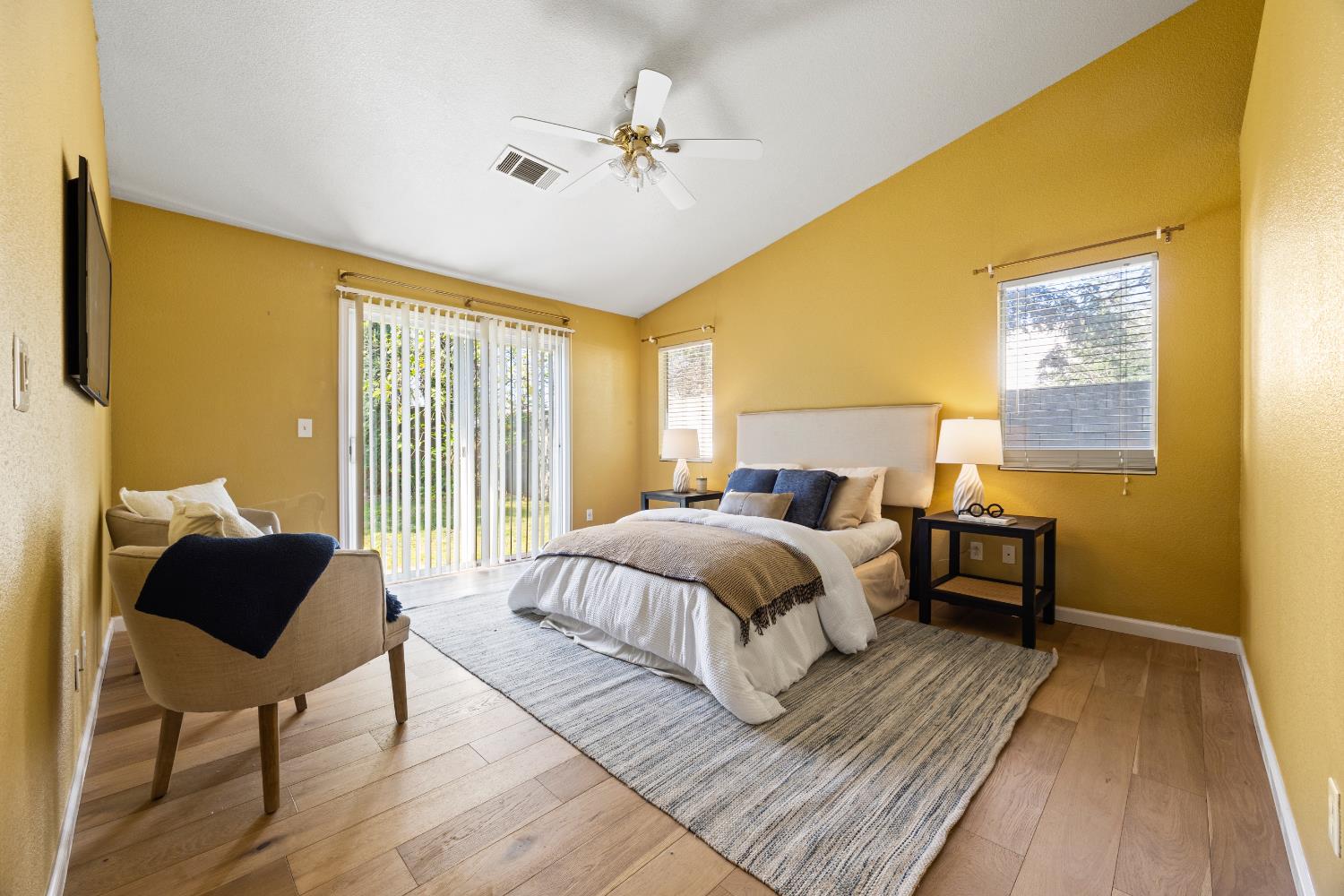 8926 Generations Court Elk Grove, CA 95758 - Photo 16 of 23 a spacious bedroom with a bed a couch and a window
