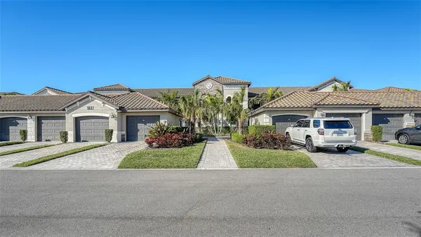 a front view of a house with yard and parking