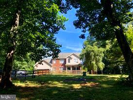 7575 Moormont Road Rapidan, VA 22733 - Photo 1 of 59 a front view of a house with a garden and trees