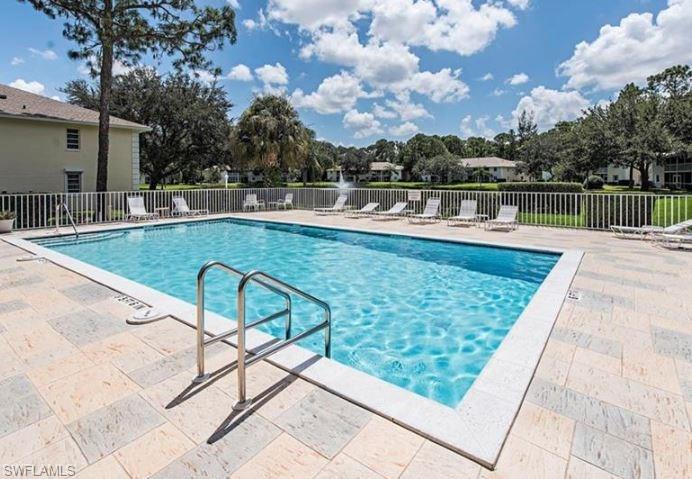 240 Timber Lake Circle, Unit D202 Naples, FL 34104 - Photo 20 of 23 a view of a swimming pool with a lounge chairs