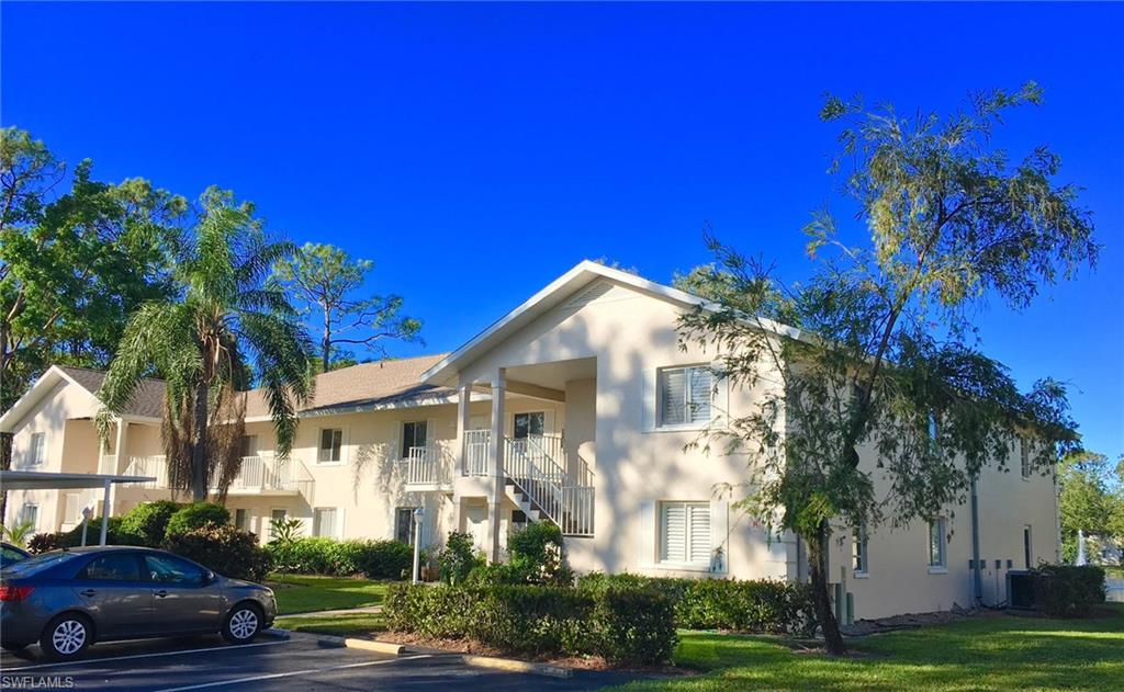 240 Timber Lake Circle, Unit D202 Naples, FL 34104 - Photo 22 of 23 a front view of a house with a yard
