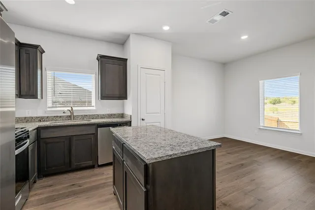 a kitchen with stainless steel appliances granite countertop a refrigerator and a stove