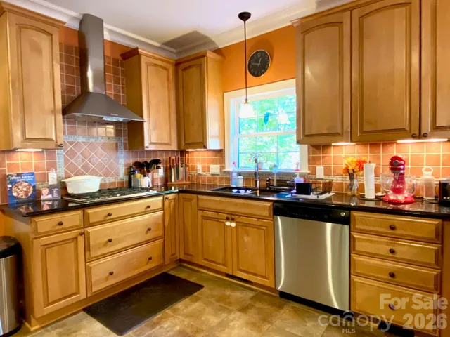 a kitchen with stainless steel appliances granite countertop a sink and a stove